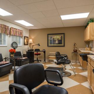 An empty hair salon with multiple chairs, mirrors, and a cozy interior design.