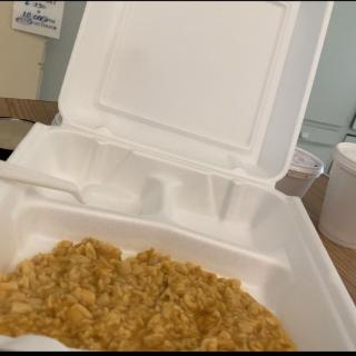 A takeout container filled with rice.