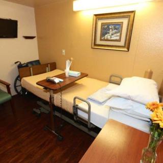 A well-equipped hospital room with a bed, wheelchair, and decorative elements.