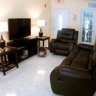 Cozy living room with leather furniture and a large TV.