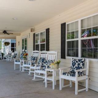A cozy porch with rocking chairs and potted plants.