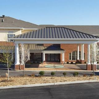 Front view of a building with a covered entrance and columns.