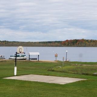 A peaceful lakeside view with a grassy area and a dock.