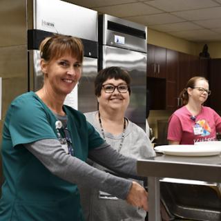 A dedicated team of staff members smiling in a kitchen environment.
