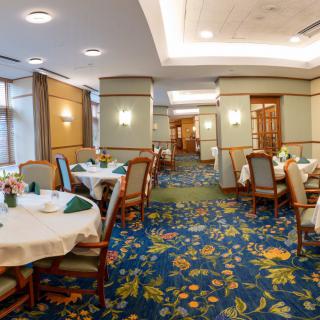 A spacious and elegantly decorated restaurant dining area with neatly arranged tables and chairs.