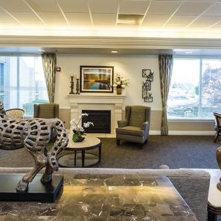 A well-decorated living room featuring a fireplace, artwork, and a horse sculpture.