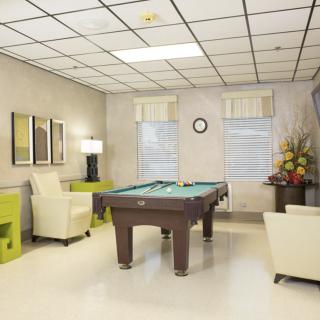 A modern game room featuring a pool table and comfortable seating.