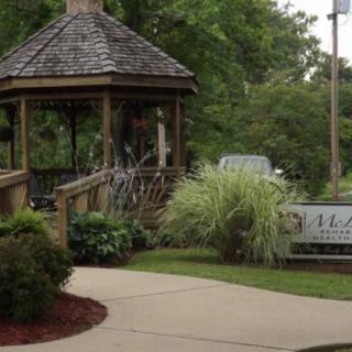 A charming gazebo surrounded by lush greenery and a winding pathway.