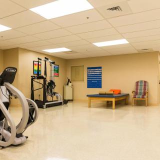 A rehabilitation or fitness room with exercise equipment and therapy table.