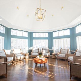 A bright and airy sunroom with ample seating and large windows.