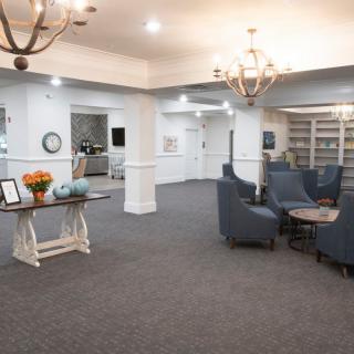 A spacious and elegantly decorated lounge area with comfortable seating and chandeliers.