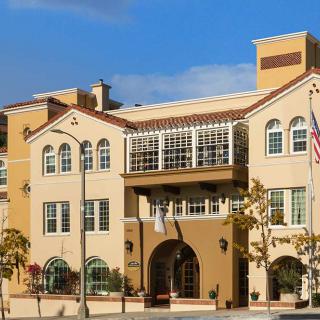 A multi-story residential building with a modern architectural design against a clear blue sky.