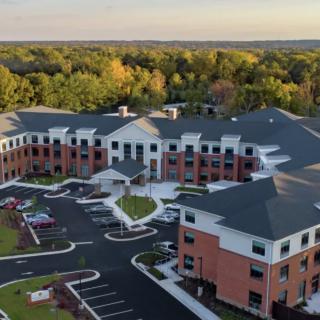 Aerial view of a large residential or commercial building complex surrounded by trees.