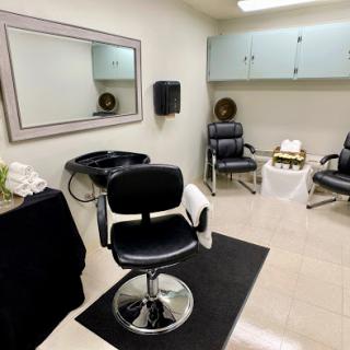 A neatly arranged hair salon interior featuring styling chairs and a wash station.