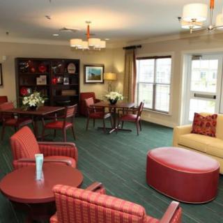 A cozy living room with red furniture and ample natural light.