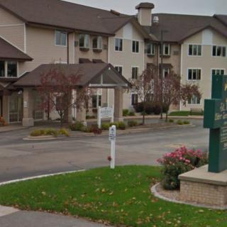 A residential apartment complex with a landscaped driveway and entrance.