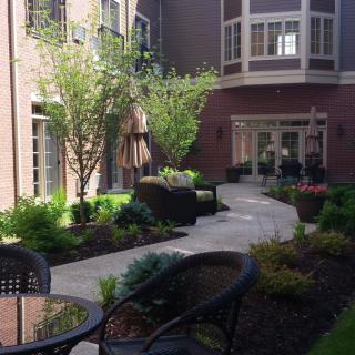 A beautifully landscaped courtyard with a walkway and patio seating.