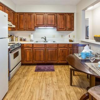 A cozy kitchen with wooden cabinets and a small dining area.