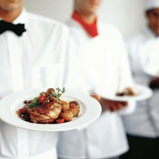 Chefs presenting elegantly plated dishes.