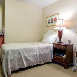 A cozy bedroom with a single bed and elegant nightstand.