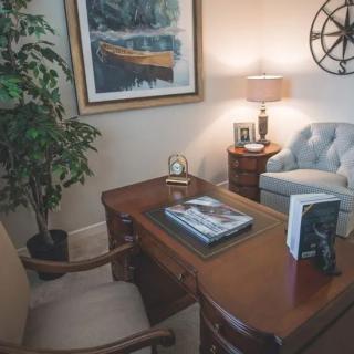 Cozy office space with a wooden desk, comfortable chairs, and decorative elements.