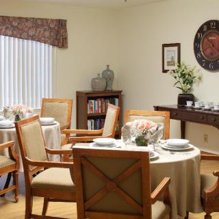 A cozy dining room with neatly set tables and comfortable chairs.