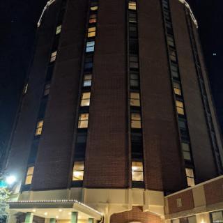 A tall hotel building illuminated at night.