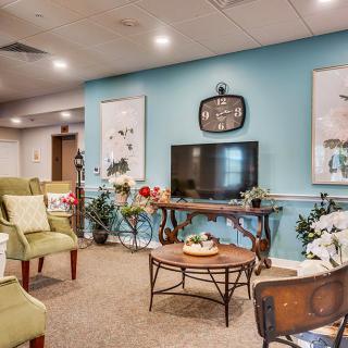 A cozy living room with comfortable seating, a television, and decorative indoor plants.