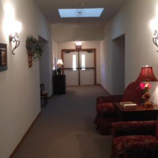 A warmly lit hallway with decorative furniture and a lamp.