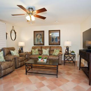 A cozy living room with sofas, armchairs, and decorative elements.