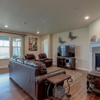 A cozy living room with leather sofas, a television, and a fireplace.