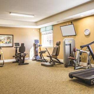 A well-equipped gym room with various exercise machines, including treadmills and bikes.