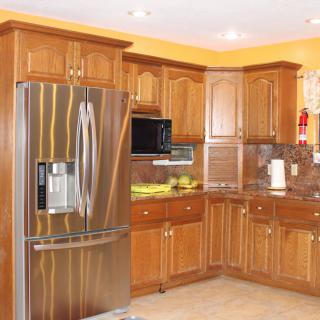 A modern kitchen featuring wooden cabinets and stainless steel appliances.