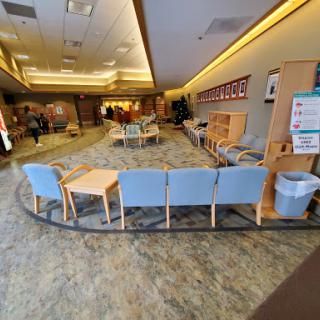 A spacious waiting area designed for comfort, featuring a circular arrangement of chairs and tables.