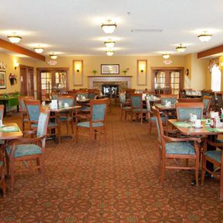 A spacious dining area with neatly arranged tables and chairs, featuring elegant decor.