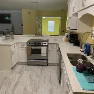 A modern kitchen with white cabinetry and a stainless steel stove.