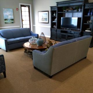 A cozy living room with two sofas, a coffee table, and an entertainment center housing a television.