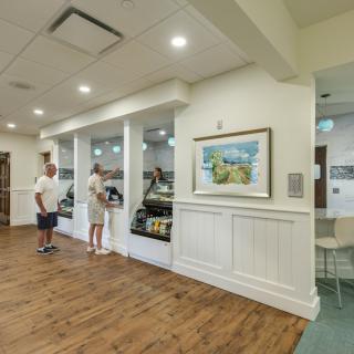A cozy cafe interior with two people standing at the counter.