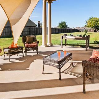 A sunny patio with comfortable outdoor seating and a view of the garden.