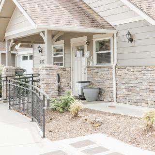A welcoming front entrance of a house with a stone facade and ramp access.
