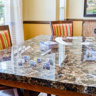 A dining room with a marble table and striped chairs.