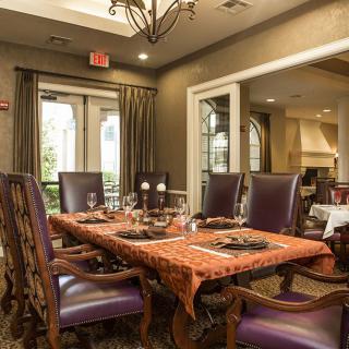 An elegant dining room with a beautifully set table and luxurious chairs.