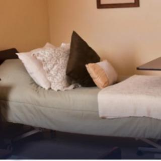 A cozy bedroom setup with pillows and a blanket on the bed.