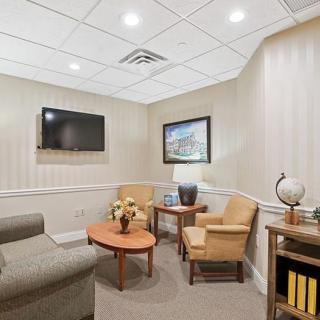 A cozy waiting room with comfortable seating, a TV, and decorative elements.