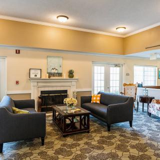 A cozy living room with matching sofas, a central coffee table, and a decorative fireplace.