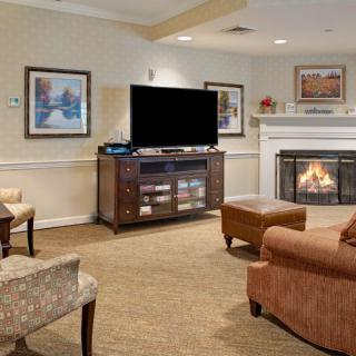A cozy living room featuring a fireplace, television, and comfortable seating.