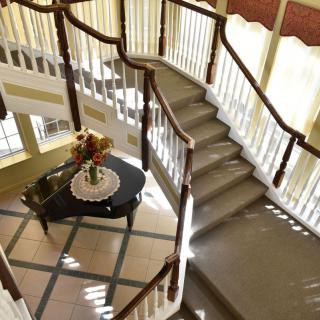 A beautifully designed interior with a grand curved staircase and elegant decor.