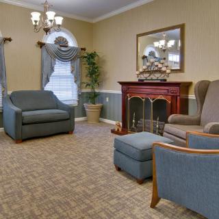 A cozy living room with a fireplace, comfortable seating, and elegant decor.