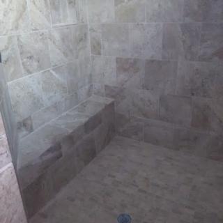 A modern shower space featuring marble tiles, showcasing a simple and elegant design.