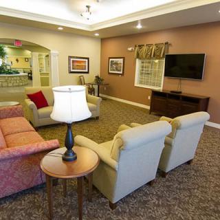 A cozy living room with a sofa, armchairs, and a television.